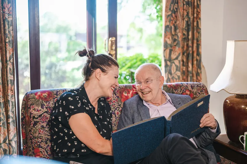 Young woman and elderly veteran laughing together